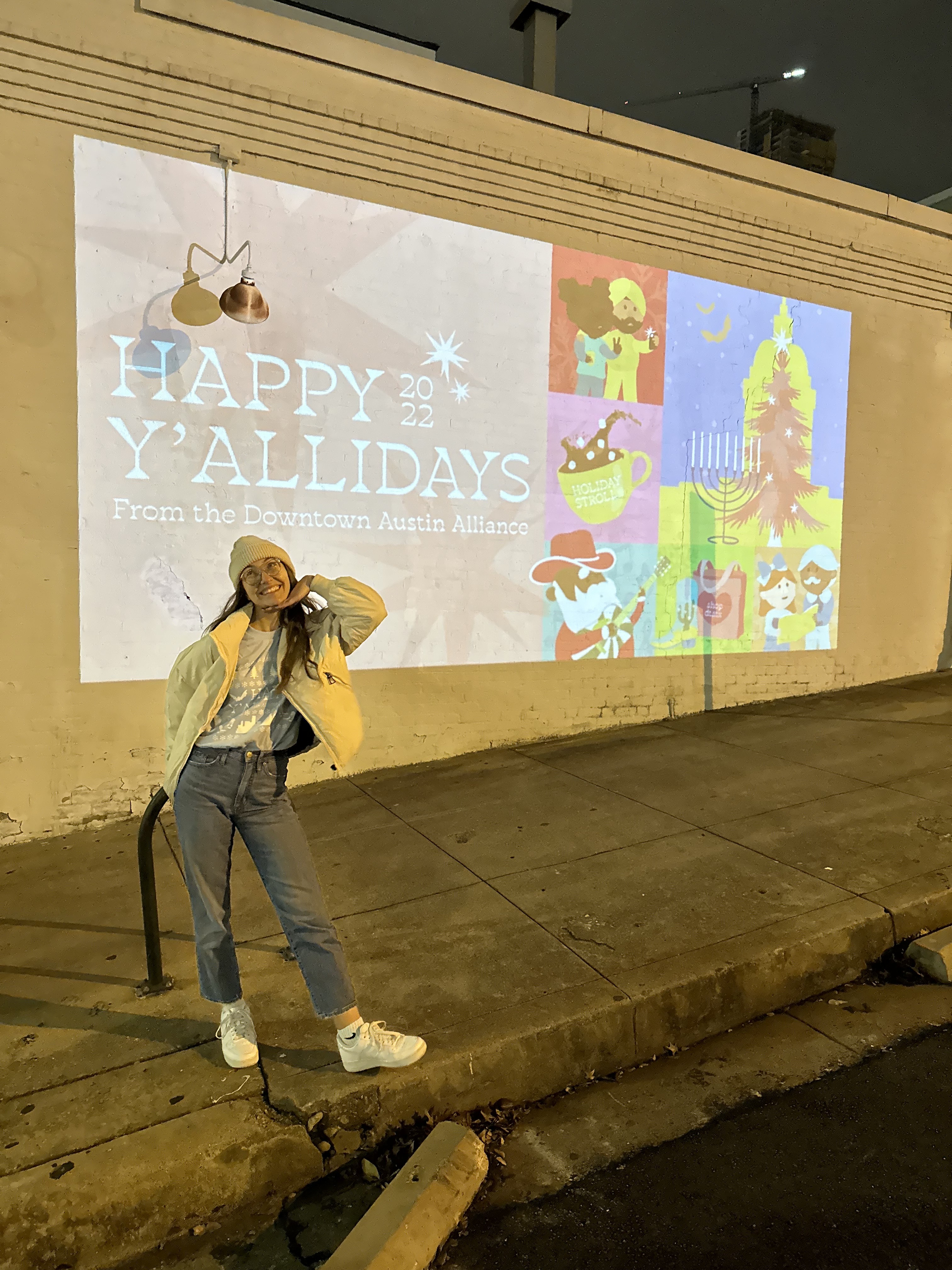 projection mural featuring event graphics on side of downtown building designed by ashley rose marino of ashrose creative. sign featuring "happy y'allidays" message
